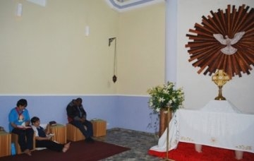 Paroquianos em adoração e oração na capela diante do Santíssimo