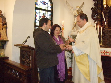 El P. Vitor en entrega la cruz para el Santuario de Porto a un matrimonio de Portugal