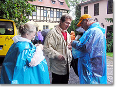 Sozialminister Dr. Zeh im Gespräch mit vom Regen durchnässten Pilgern