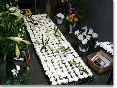 Der Ort seines Sterbens ist mit einem Teppich aus weißen Lilien und Nelken geschmückt