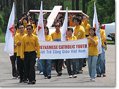 Die katholische vietnamesische Jugend bringt das Kreuz zum Heiligtum