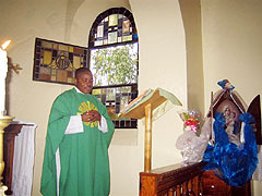 Pater Jean-Bernard, erster kongolesischer Schoenstattpater zelebriert im Heiligtum in Isingiro die Heilige Messe und spricht über die Bedeutung der Auxiliar-Pilgermutter.