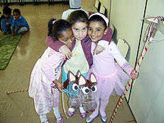 Die drei verkleideten Mädchen präsentieren stolz ihre selbst gebastelten Steckenpferde aus alten zwei Liter Plastikflaschen