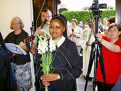 Eine Marienschwester aus Kenia trägt einen Blumenstruaß zum Altar – und Afrika schaut zu