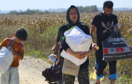 Sid, Serbia - September 18th, 2015: Syrian family walking on the dirt road, preparing to cross the border between Serbia and Croatia, looking for a new life. Mother, father and the son, going to a better future in the EU countries.